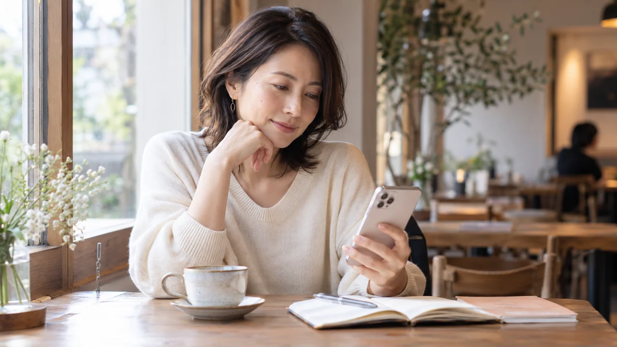 カフェでスマートフォンを見る女性